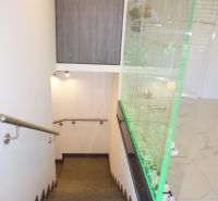 Stairs with handrails next to a glass wall, floor with wood decor in warehouses and halls.