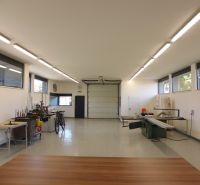 Interiors of warehouses and halls with equipment, white walls, and floors with wood decor.
