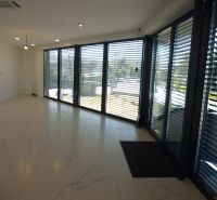 Interior of warehouses and halls with large glass windows and marble-patterned tiles.