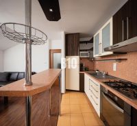 A kitchen with a counter and floor with wood decor in a 2-room apartment.