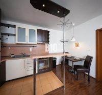 Kitchen unit and dining area in a 2-room apartment with a wooden decor floor.