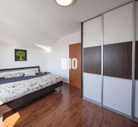 Bedroom in a 2-room apartment with a bed and built-in wardrobe, floor with wood decor.