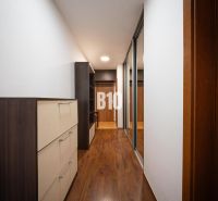A hallway in a 2-room apartment with a wooden decor floor and built-in wardrobes.