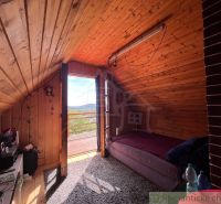 The attic of the cottage with a sloped ceiling and a view of the surrounding landscape.