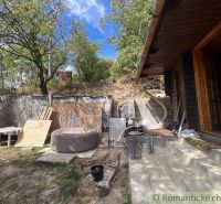 The exterior of the cottage in Bratislava IV with a hot tub, stairs, and greenery.