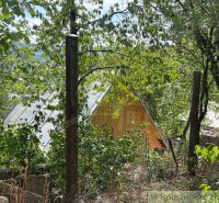 A wooden cabin in the nature of Bratislava IV surrounded by trees and greenery.