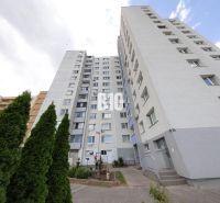 A large apartment building in Bratislava IV surrounded by greenery and sky.