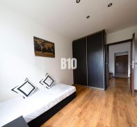 A simple room with storage cabinets, a bed, and a wooden decor floor in a 3-room apartment.