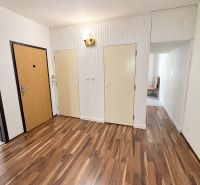Interior of a 3-room apartment with a wooden decor floor and white walls.