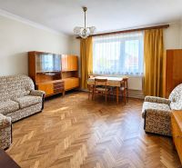 A living room in a family house with antique furniture and a wood-patterned floor.