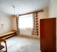 A room in a family house with furniture and curtains on the window.