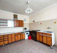 A kitchen in a family house with retro cabinets and a built-in stove.