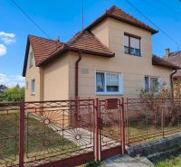A family house in Oslany with a sloped roof and a decorative metal fence.