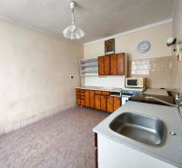 A kitchen in a family house with a wooden decor floor and retro furniture.