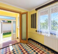 The entrance hall of a family house with colorful tiles and large windows.