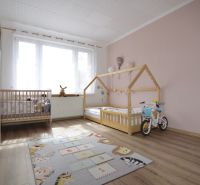 Children's room with wooden decor flooring in a 4-room apartment, playful rug.