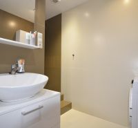 A bathroom with a sink, cabinet, shelf, and washing machine in a 4-room apartment.