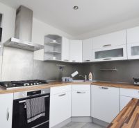 A kitchen in a 4-room apartment with white cabinets and stainless steel appliances.
