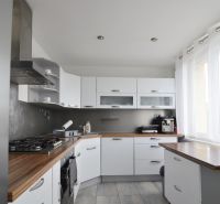 A kitchen in a 4-room apartment with built-in appliances and a floor with a wooden decor.