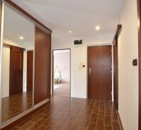 Entrance hall in a 4-room apartment with a wood-decor floor and a built-in wardrobe.