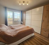 Bedroom in a 4-room apartment with a large wardrobe and a wooden decor floor.