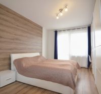 Bedroom with wood-patterned flooring in a 4-room apartment, bright space.