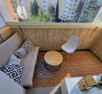 Balcony with seating and flooring with a wood decor in a 4-room apartment.