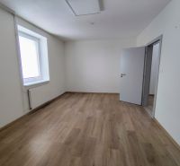 Offices with wood-patterned flooring and windows in a white interior.