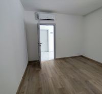 A room in an office with a wooden decor floor and air conditioning.