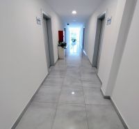 A hallway in an office with light walls and flooring, located in Nitra - Chrenová.
