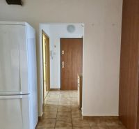 A hallway in a 3-room apartment with a ceramic floor and a white refrigerator.