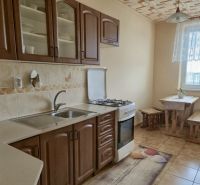 A kitchen in a 3-room apartment with a gas stove and a dining area.