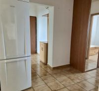 A hallway in a 3-room apartment with tiles and a white refrigerator.