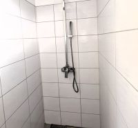 A shower enclosure with a square head and white tiles in a family house.