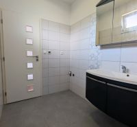 A bathroom with a sink and a mirrored cabinet in a family house.