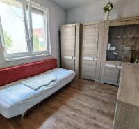 A simple room with a bed, wardrobes, and a wooden decor floor in a family house.