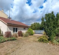 A family house in Matúškovo with a front garden, surrounded by greenery under a cloudy sky.