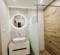 Bathroom with a sink, mirror, and shower, floor with wooden decor, 3-room apartment.