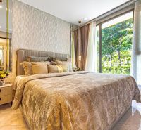 Bedroom in a holiday apartment with a comfortable bed and a large window.