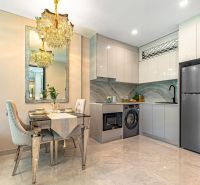 A kitchen with a dining area in a holiday apartment with soft lighting and glossy surfaces.