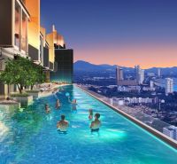 A pool with a panoramic view of Jomtien city from a holiday apartment during sunset.