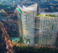 A high-rise building of a recreational apartment in Jomtien illuminated by surrounding city lights.