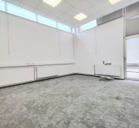 Interior of a commercial space with large windows and a gray floor with decor.