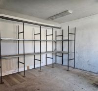 Shelves in a garage with a concrete floor and white walls.