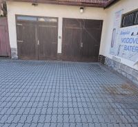 Wooden garage doors on Metodova Street in Prešov, paved yard.