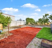 A garden at a family house in Povoda with a car and artificial turf.