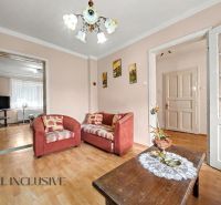 Living room with sofas and wood-patterned flooring in a family house.