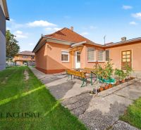 A family house in Povoda with a garden seating area, green lawn, and colorful facade.