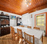 A dining room in a family house with a wooden decor floor and rustic furniture.