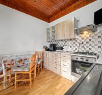 A kitchen in a family house with furnishings, a kitchen unit, and flooring with a wood decor.